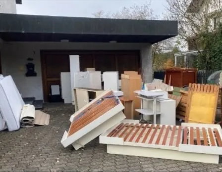 Alte Möbel und Lattenroste vor einer Garage vor der Abholung